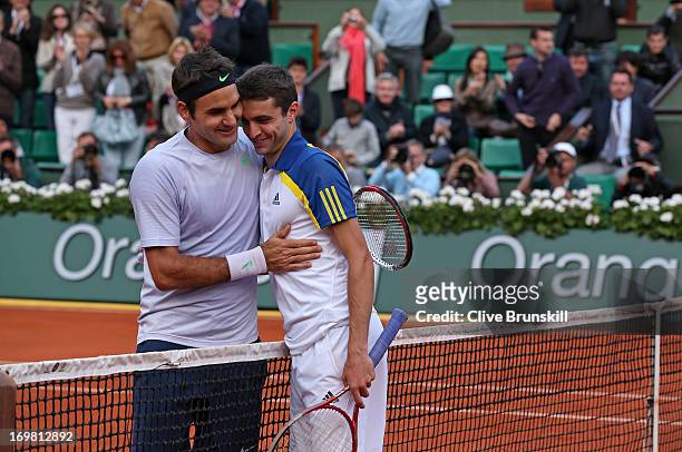 Roger Federer of Switzerland hugs Gilles Simon of France after their Men's Singles match during day eight of the French Open at Roland Garros on June...