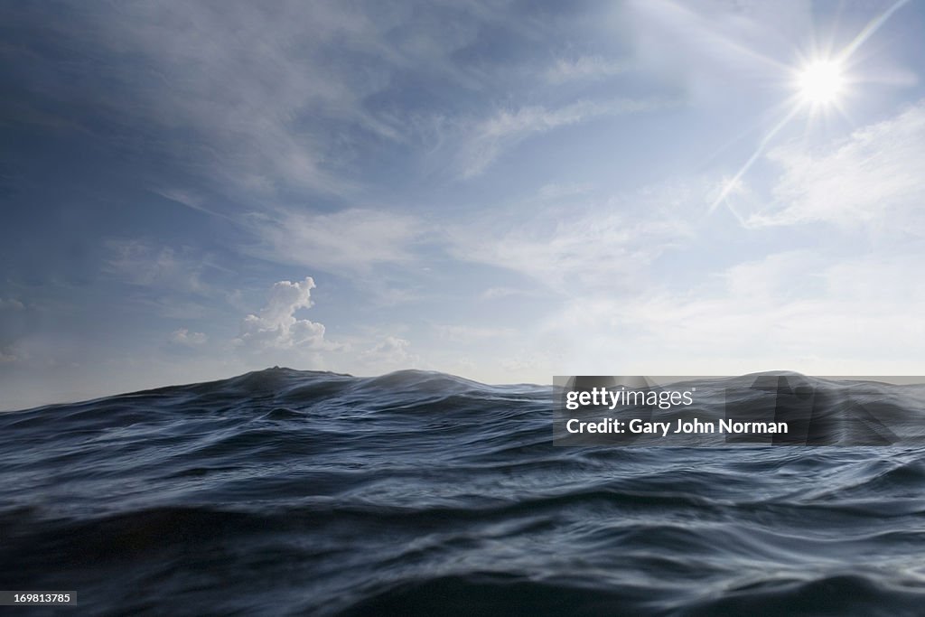 Dramatic dark sea with sun in sky