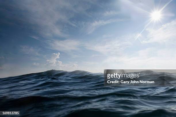 dramatic dark sea with sun in sky - superfície de água - fotografias e filmes do acervo