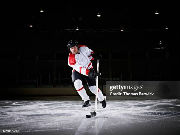 ice hockey player skating down ice with puck - centro hóquei no gelo - fotografias e filmes do acervo