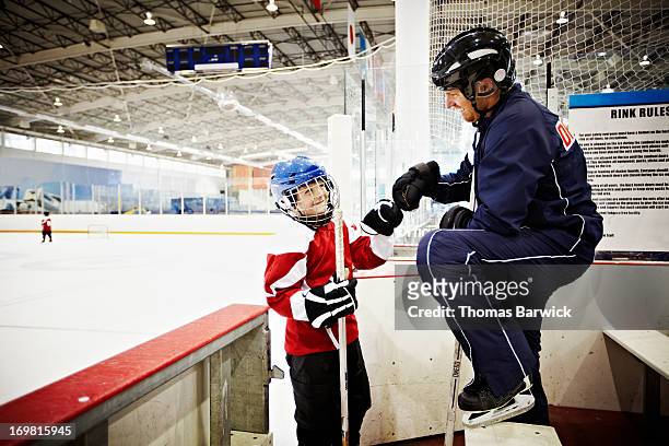 hockey coach giving young player a fist bump - respect kids stock pictures, royalty-free photos & images