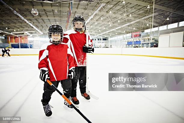 young male and female ice hockey players on ice - hockey kids stock-fotos und bilder