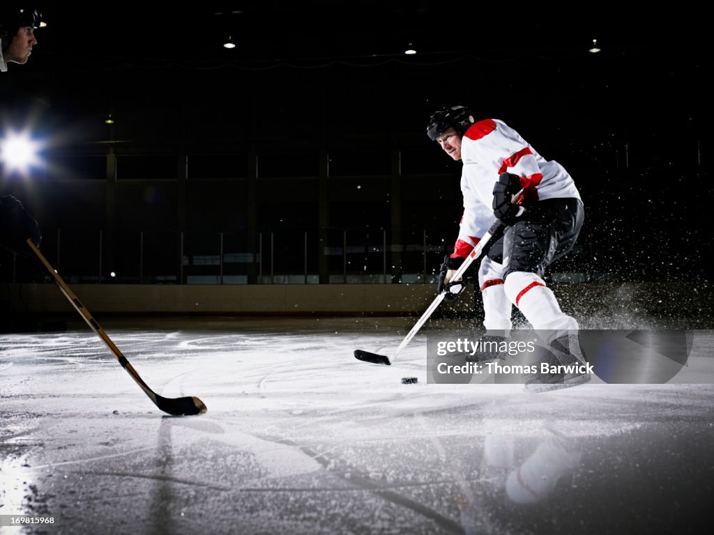 Ice hockey player attempting to avoid defender