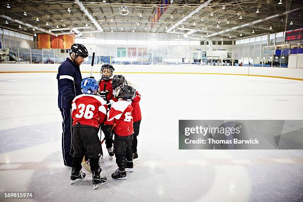 ice hockey coach encouraging young team - centro hóquei no gelo - fotografias e filmes do acervo