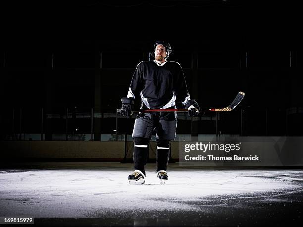 portrait of ice hockey player standing on ice - ice hockey glove stock-fotos und bilder