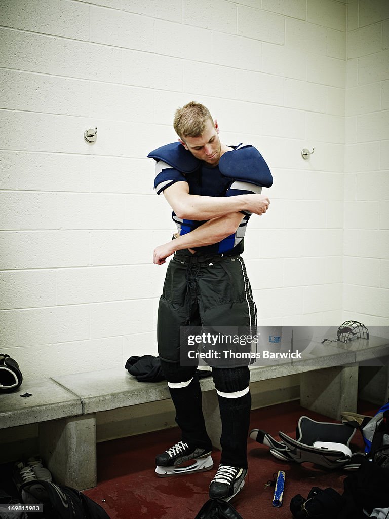 Ice hockey player putting on hockey pads