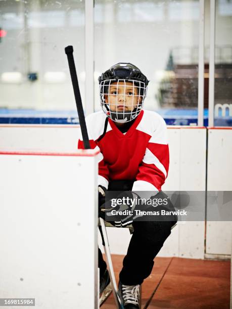 young ice hockey player sitting on players bench - indoor ice rink stock pictures, royalty-free photos & images