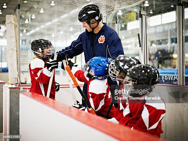 hockey coach congratulating young female player - girls ice hockey stock pictures, royalty-free photos & images