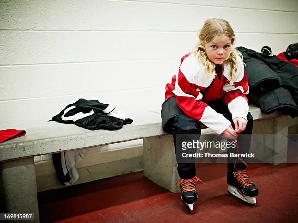 Young female hockey player in locker room