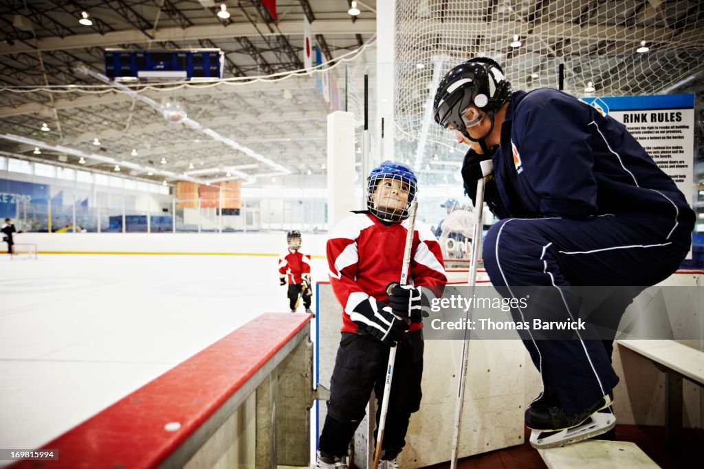 Hockey coach encouraging young hockey player