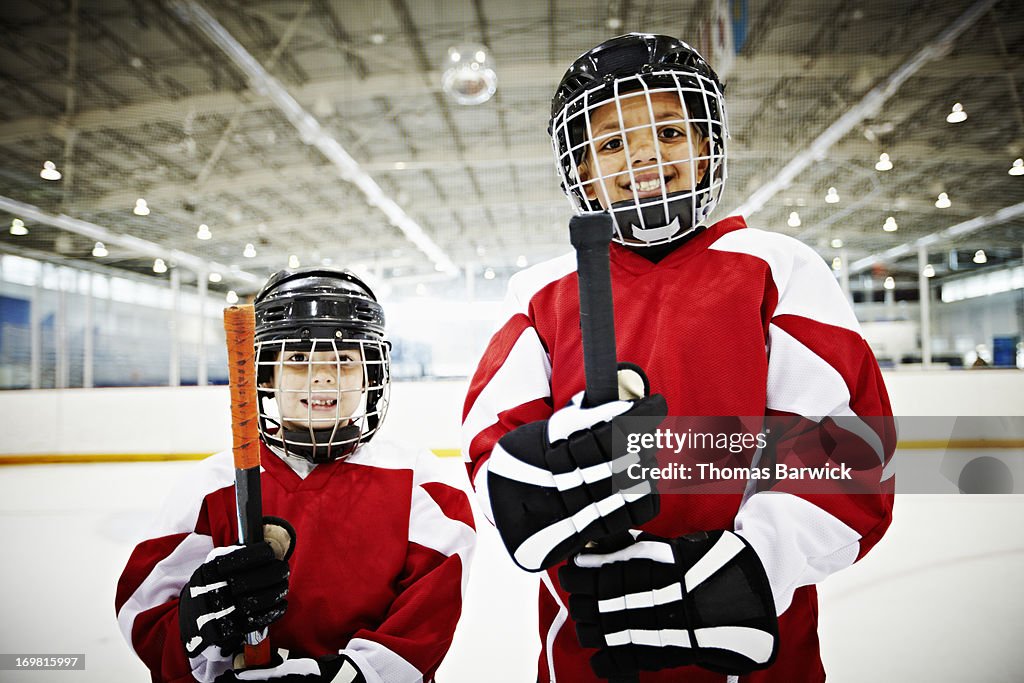 Smiling young hockey players standing on ice