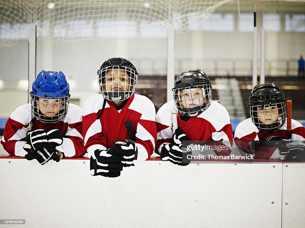 Young ice hockey players in players box