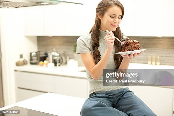 woman eating chocolate cake - eating cake stockfoto's en -beelden