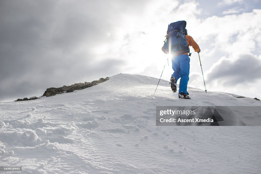 Mountaineer ascends towards snow summit
