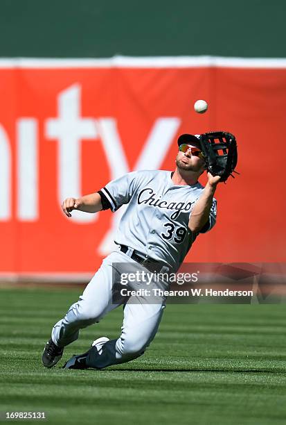 Right Fielder Casper Wells of the Chicago White Sox goes into a slide to catch a shallow fly ball taking a hit away from Chris Young of the Oakland...