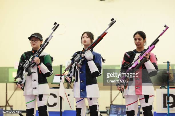 Han Jiayu of Team China, Huang Yuting of Team China and Ramita of Team India in action during the Shooting - Women's 10m Air Rifle Final on day one...