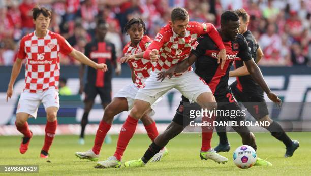 Mainz' German defender Stefan Bell and Bayer Leverkusen's Nigerian forward Victor Boniface vie for the ball during the German first division...