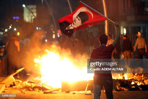 An anti-government protester waves Turkey's national flag bearing a portrait of Mustafa Kemal Ataturk, founder of modern Turkey, during a...