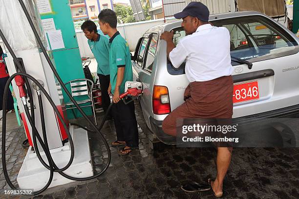 Gas station attendants refuel a motorist's vehicle at an MMTM gas station in Yangon, Myanmar, on Sunday, June 2, 2013. Myanmar may attract as much as...