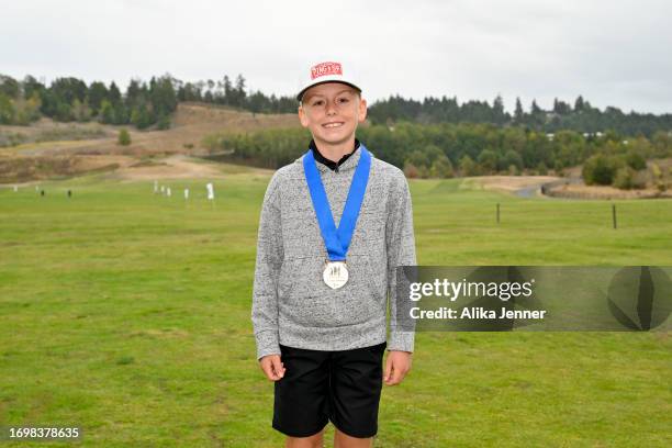Regional qualifier Emery Johnson, winner of the boys 10-11 division, poses wearing the first place medal during the 2023 Drive, Chip and Putt...