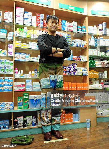 Performance artist Liu Bolin is photographed for Paris Match during preparation for a work which takes place at a pharmacist's and is a commentary on...