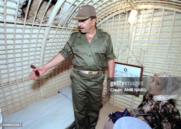 An Egyptian Major-General displays to Arab visitors the bed used during the 1973 October War by the chief of a former Israeli fortified point in the...