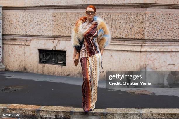 Guest wears fur jacket, pants, top with print, brown bag, sunglasses outside Missoni during the Milan Fashion Week - Womenswear Spring/Summer 2024 on...