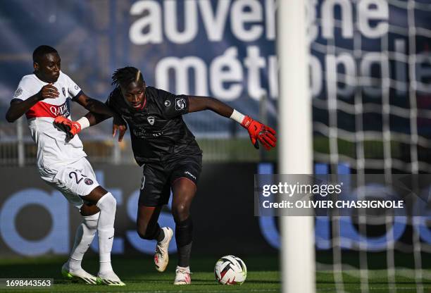 Clermont-Ferrand's French goalkeeper Mory Diaw fights for the ball with Paris Saint-Germain's French forward Randal Kolo Muani during the French L1...