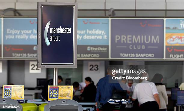 Passengers wait to be served at Thomson Airways check-in desks, a unit of TUI Travel Plc, at Manchester Airport in Manchester, U.K., on Friday, May...