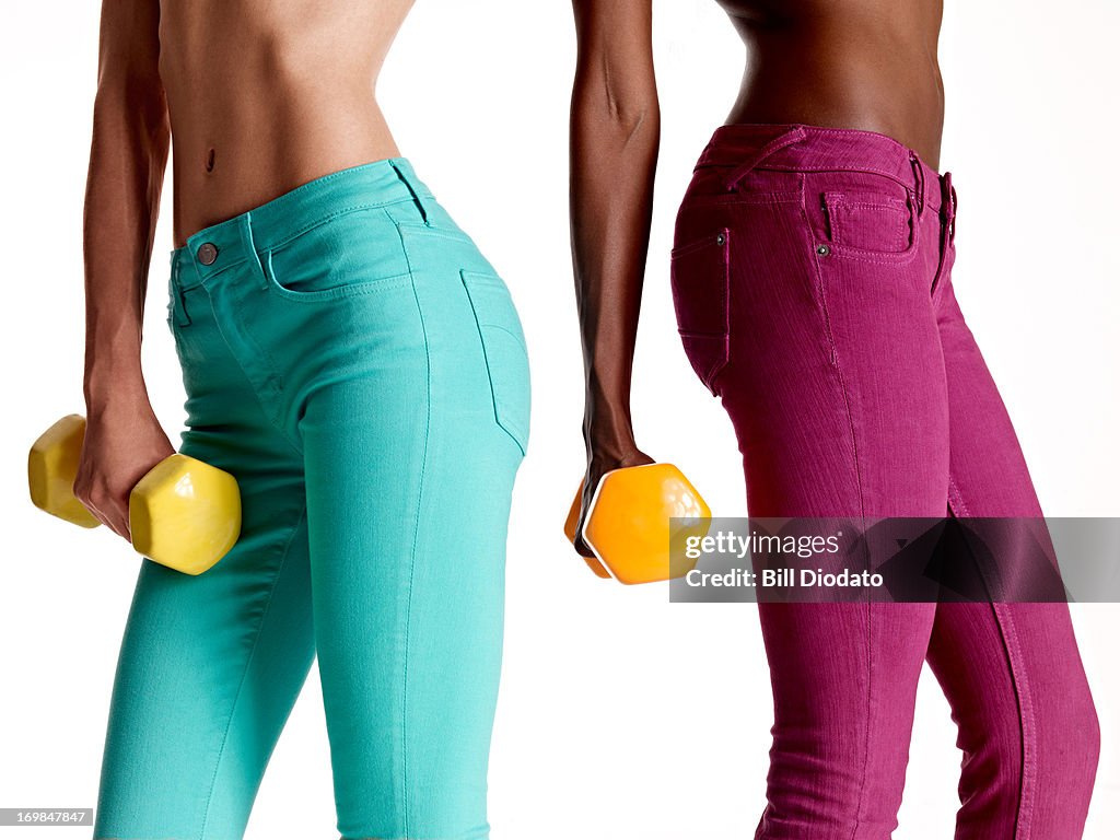 Two girls holding dumb bells