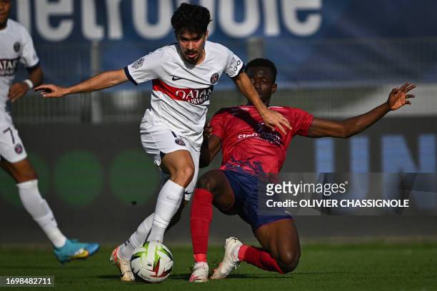 Paris Saint-Germain's Portuguese midfielder Vitinha fights for the ball with Clermont-Ferrand's Malian defender Cheick Oumar Konate during the French...