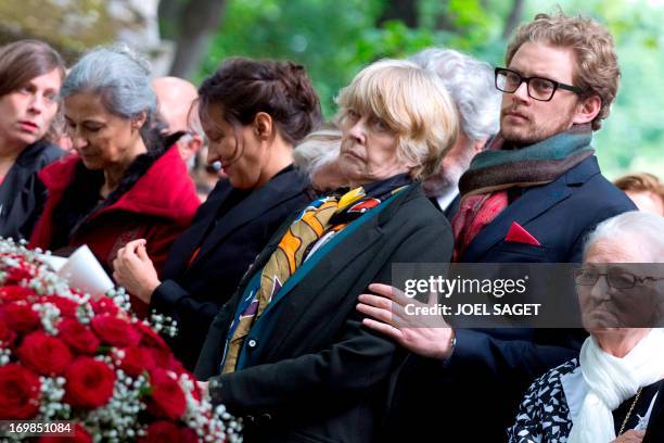 Widdow of late Guy Carcassonne, Claire Bretecher and her son Martin stand on June 3, 2013 at the Montmartre cemetery in Paris, during the funeral of...