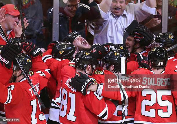 Brent Seabrook of the Chicago Blackhawks yells as teammates join him in celebration after he scored the winning goal in overtime against against the...