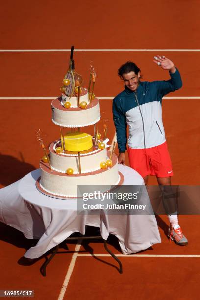 Rafael Nadal of Spain waves to the crowd after being presented with a birthday cake after victory in his Men's Singles match against Kei Nishikori of...