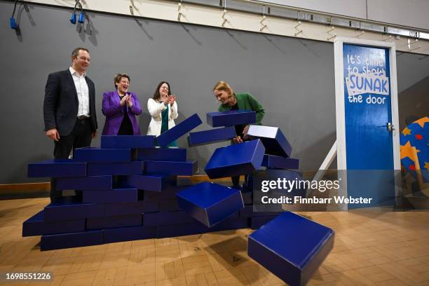 Liberal Democrat by-election winners, Richard Foord, Sarah Dyke, Sarah Green and Helen Morgan, smash through the blue wall prop during a visit to...