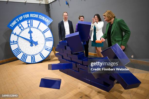 Liberal Democrat by-election winners, Richard Foord, Sarah Dyke, Sarah Green and Helen Morgan, smash through the blue wall prop during a visit to...