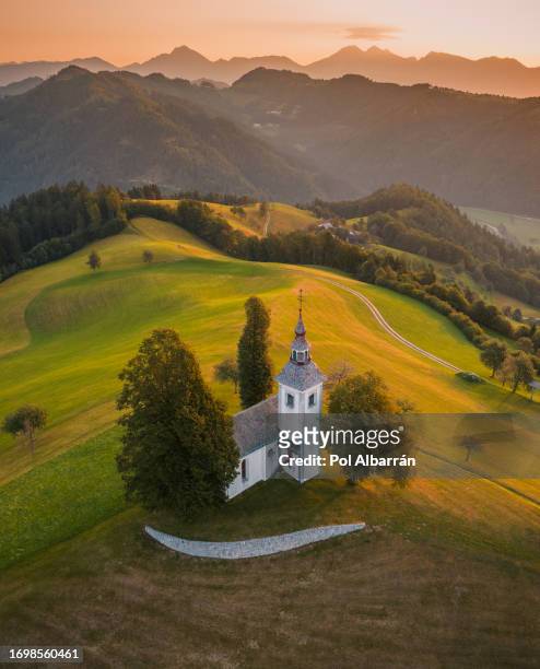 aerial drone view of small beautiful church on top of a mountain in slovenia at sunrise. beautiful summer morning landscape. cerkev sveti tomaž (st. thomas church) - lubiana fotografías e imágenes de stock