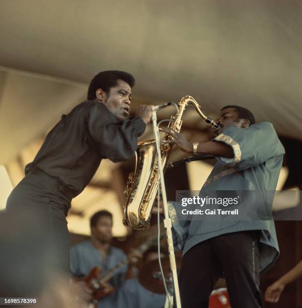 American singer and musician James Brown and American saxophonist St Clair Pinckney perform in concert at the Newport Jazz Festival in Newport, Rhode...