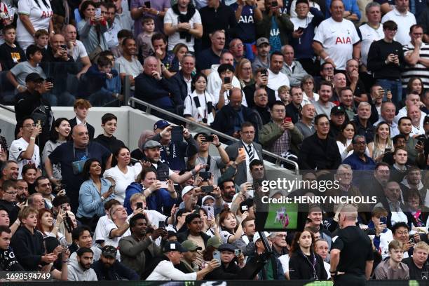 Referee Simon Hooper watches a VAR during the English Premier League football match between Tottenham Hotspur and Liverpool at Tottenham Hotspur...