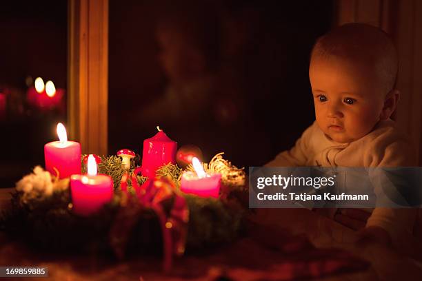 baby looking at advent wreath with candles - advent wreath stock pictures, royalty-free photos & images