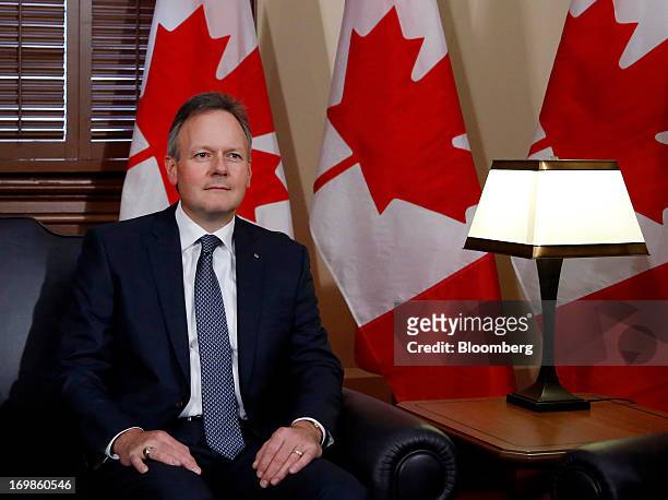 Stephen Poloz, governor of the Bank of Canada sits for photographers while being welcomed into office by Stephen Harper, Canada's prime minister, not...