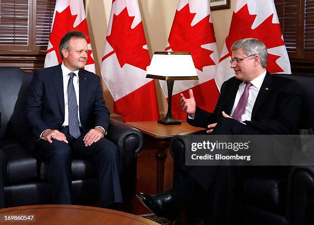 Stephen Poloz, governor of the Bank of Canada, left, speaks with Stephen Harper, Canada's prime minister, while being welcomed into office in Ottawa,...