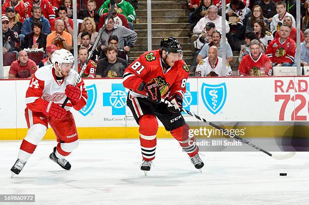 Marian Hossa of the Chicago Blackhawks approaches the puck as Gustav Nyquist of the Detroit Red Wings follows behind in Game Seven of the Western...