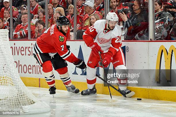 Drew Miller of the Detroit Red Wings approaches the puck as Brent Seabrook of the Chicago Blackhawks reaches from behind in Game Seven of the Western...