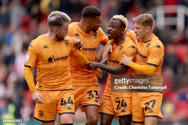 Cyrus Christie and Regan Slater of Hull City intervene as teammates Aaron Connolly and Jean Michael Seri clash whilst leaving the field at half time...