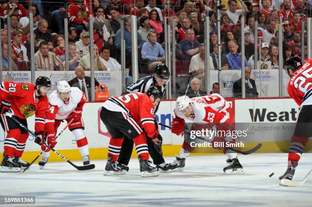 Andrew Shaw of the Chicago Blackhawks and and Joakim Andersson of the Detroit Red Wings wait for the puck to be dropped by linesman Jean Morin, as...