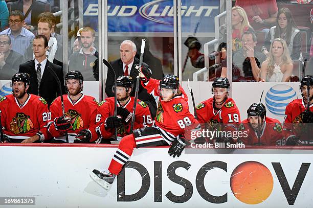 Patrick Kane of the Chicago Blackhawks leaves the bench as head coach Joel Quenneville and assistant coach Jamie Kompon stand behind in Game Seven of...