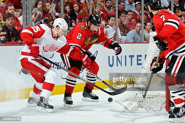 Cory Emmerton of the Detroit Red Wings and Duncan Keith of the Chicago Blackhawks battle for the puck in Game Seven of the Western Conference...