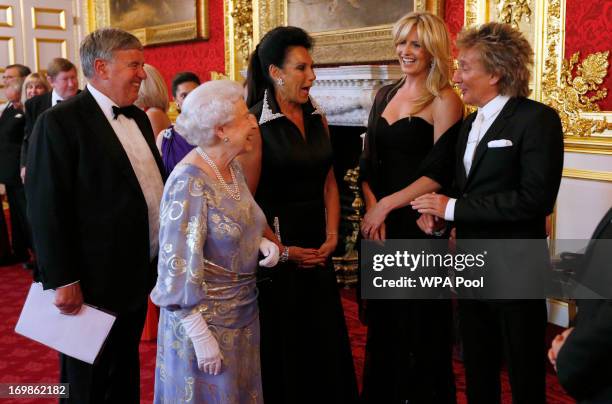 Queen Elizabeth II greets Penny Lancaster and Rod Stewart during a reception for the Royal National Institute for the Blind at St James Palace on...