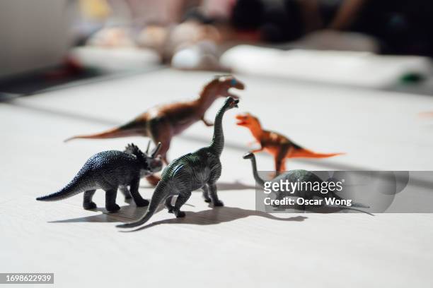 close-up of toy dinosaurs on the floor in living room - toy animal stock pictures, royalty-free photos & images